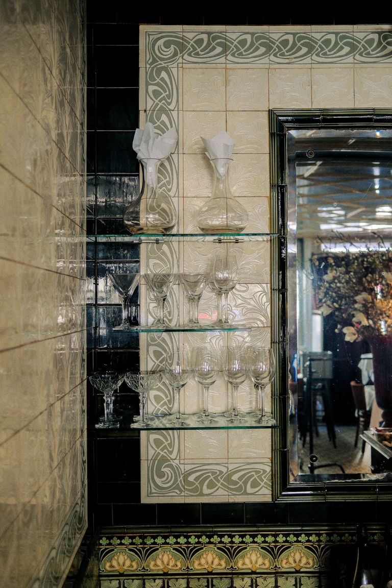 Weinglas-Vitrine vor Jugendstil-Kacheln im Restaurant Rexrodt